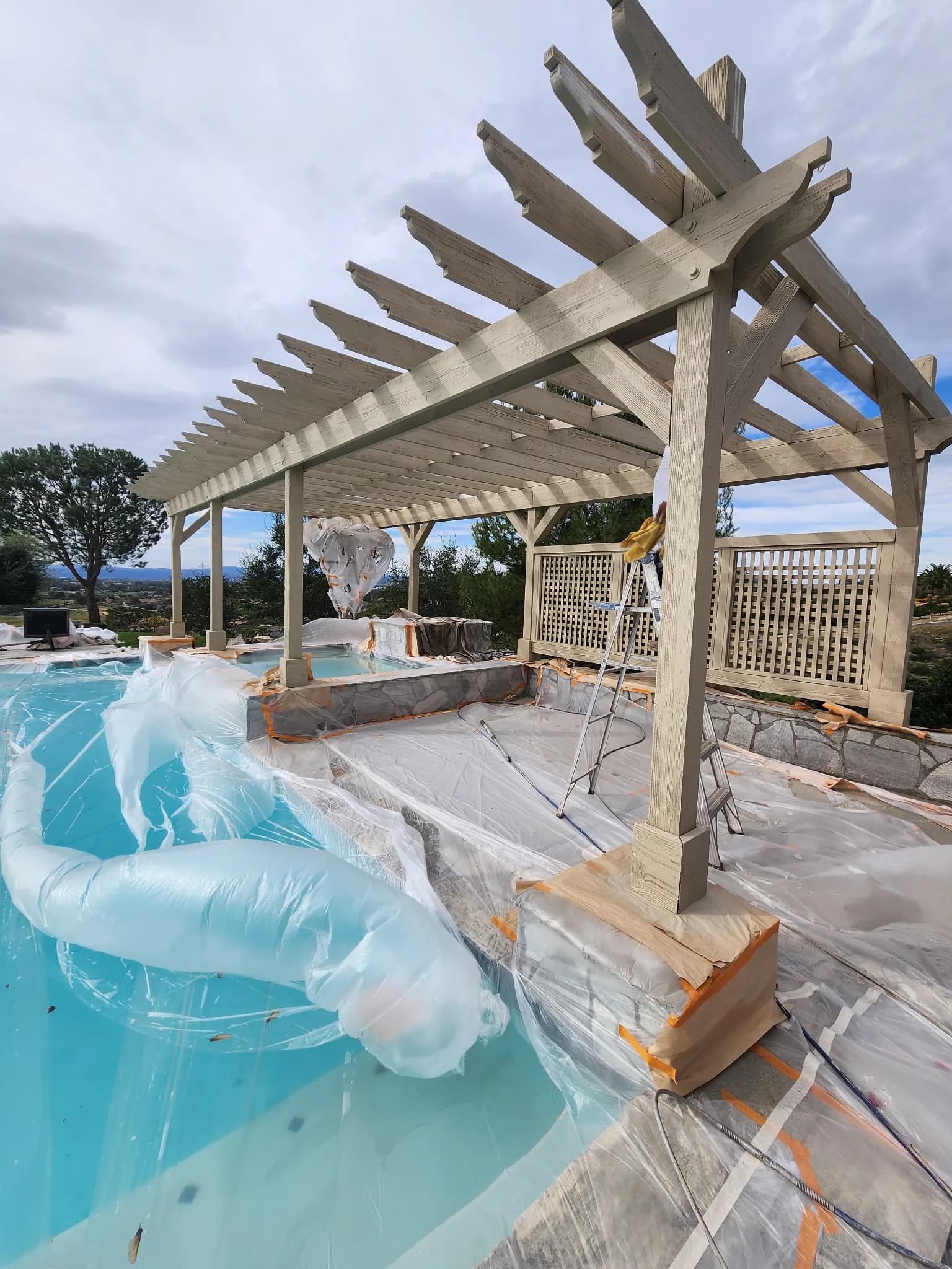 Pergola masked and prepped for stain, before
